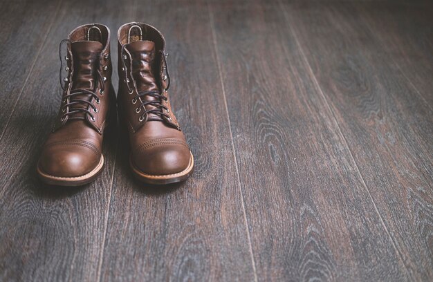 木製の床にメンズヴィンテージスタイリッシュな革のブーツ