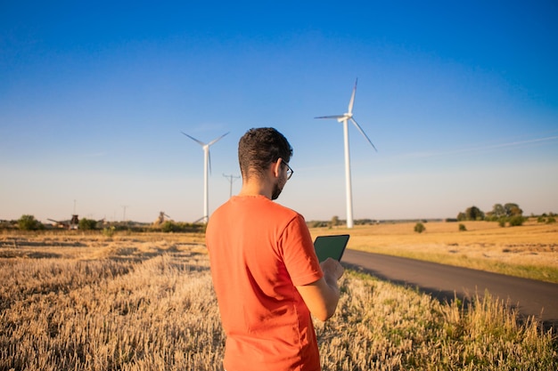 men watching windmills and watching at tablets