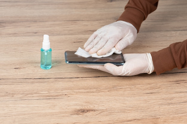 Men wear white gloves, use alcohol-free cloths and spills to clean their mobile phones to prevent viruses.