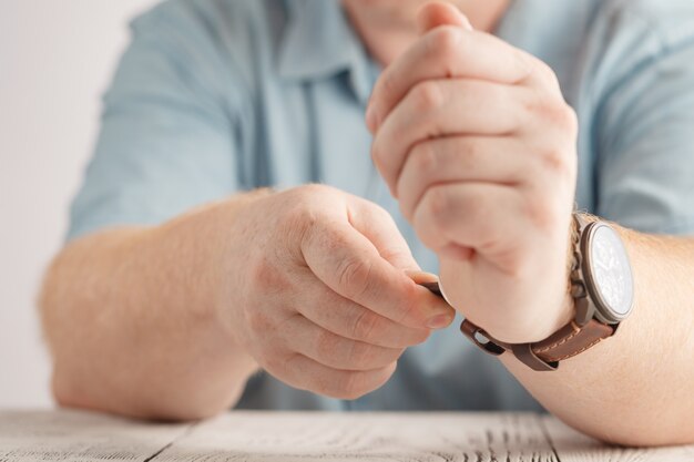 Men wearing a black watch with black leather strap over a white