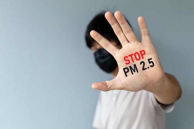 Uomini che indossano una maschera per proteggere l'inquinamento atmosferico e la polvere pm25 mostrando il palmo della mano