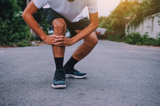 Uomini con dolore al ginocchio mentre fanno jogging