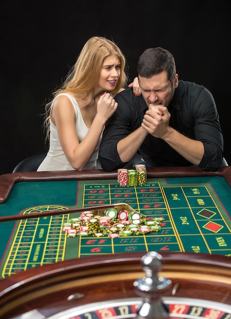 Мужчины с женщинами играют в рулетку в казино