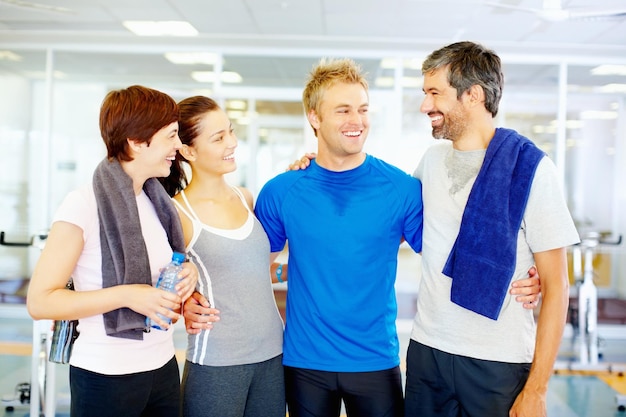 Мужчины и женщины после тренировки вместе Счастливые мужчины и женщины в фитнес-центре