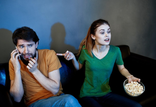 Men and women on the couch In a dark room watching a horror movie High quality photo