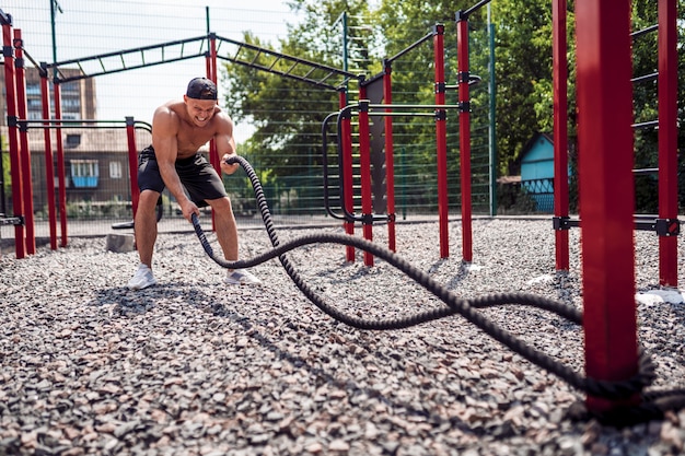 Men work hard with rope, functional training