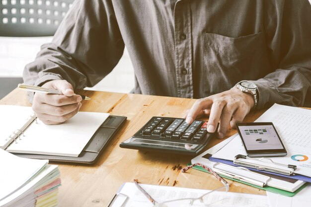 Men work with calculators and documents placed on desks