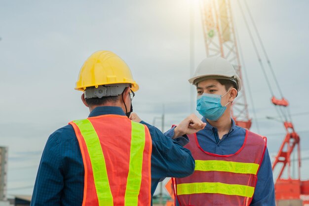 Men working with arms raised standing in background