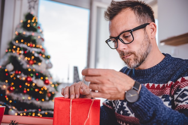 クリスマスプレゼントを包む男性