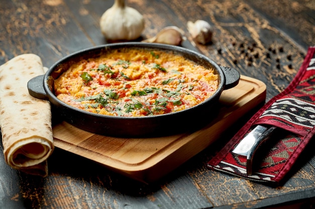 Menemen with eggs tomato green peppers and spices served with bread in pan Turkish breakfast