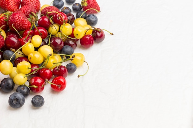 Mengsel Abrikozen met gele en rode kersen, Blueberry Aardbei op witte achtergrond. Gewichtsverlies concept