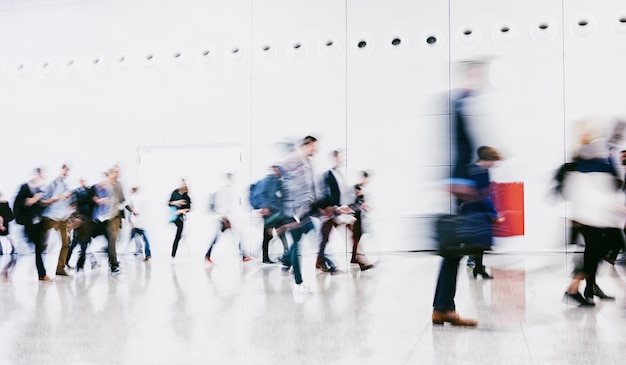 Foto menigte anonieme, wazige zakenmensen die op een luchthaven lopen. ideaal voor lay-outs van websites en tijdschriften