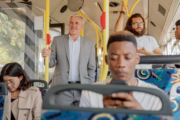 Menigte op de bus van het openbaar vervoer in de middagopstoppingen in stadsjongeren die op stoelen zitten