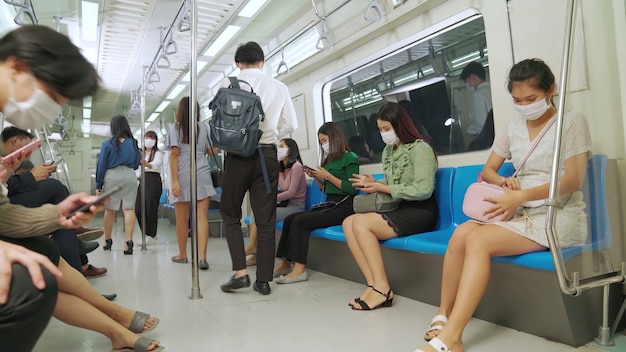 Menigte van mensen die een gezichtsmasker dragen op een drukke openbare metro