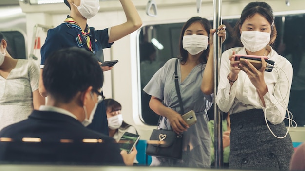 Menigte van mensen die een gezichtsmasker dragen op een drukke openbare metrotreinreis