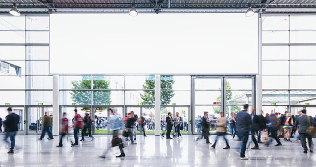 Menigte van mensen die op een handelsbeurs lopen met banner inclusief kopieerruimte. ideaal voor lay-outs van websites en tijdschriften