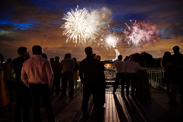 Menigte van mensen kijken naar vuurwerk in de avondlucht