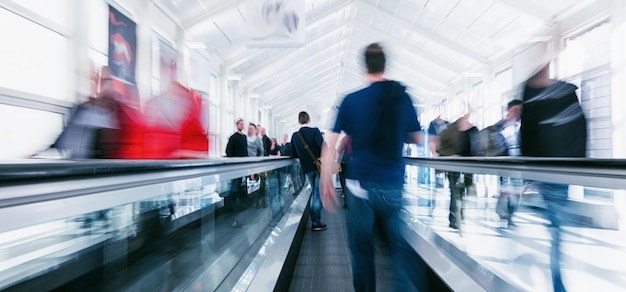 menigte van pendelaars haasten op roltrappen op een luchthaven. ideaal voor lay-outs van websites en tijdschriften