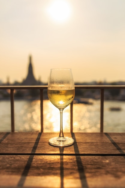 Mening van Chao Phraya River en Wat Arun-achtergrond op zonsondergang van bar &amp; restaurant met glas