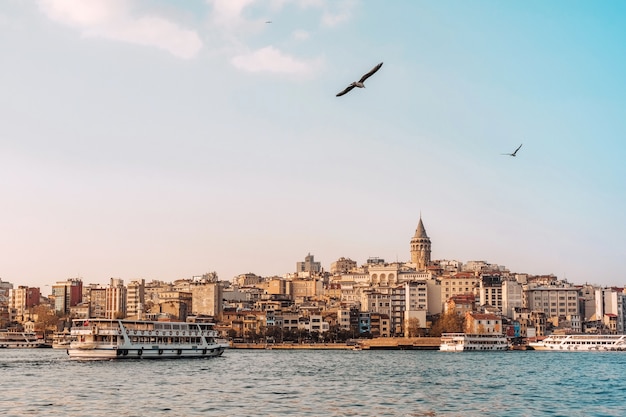 Mening van cityscape van Istanboel Galata-Toren met drijvende toeristenboten in Bosphorus, Istanboel Turkije