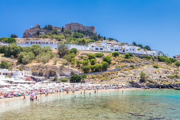 Mening van de strandmier de vesting in stad Lindos. Rhodos, Griekenland