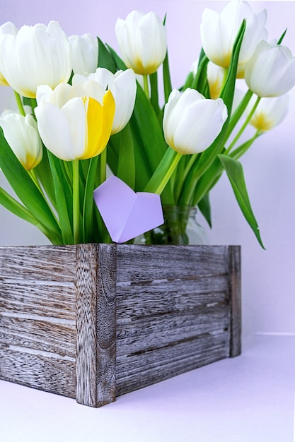 Mening van een boeket van witte tulpen die zich in een houten doos bevinden