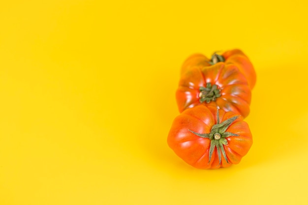 Mening van mooie rode erfstuktomaten op geel