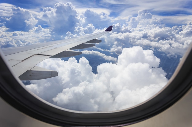 Mening van mooie wolk en vleugel van vliegtuig van venster