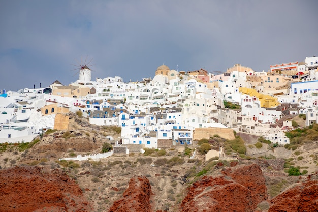 Mening van oia dorp met witte huizen op rode rotsencaldera van santorini-eiland, griekenland