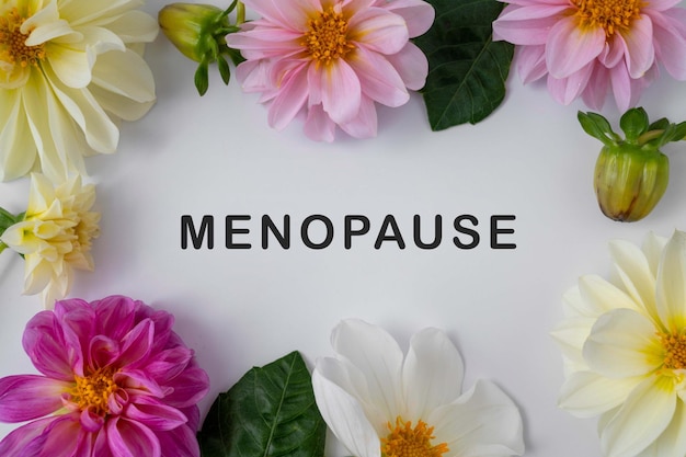 Фото Понятие здоровья женщины абстрактного слова менопаузы с цветами георгина на белых backgrouns