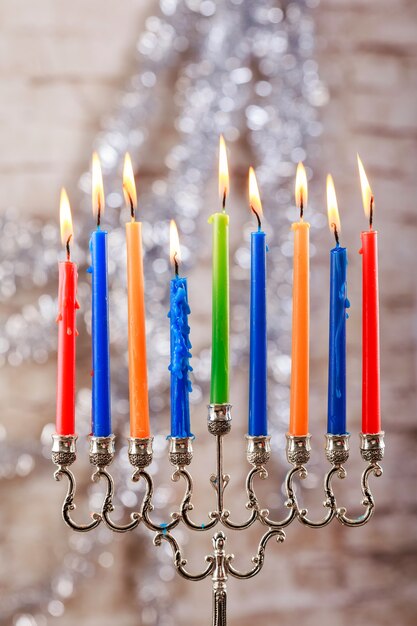 Menorah met kaarsen voor Chanoeka tegen onscherpe lichten