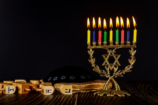 Menorah with color burning candles and dreidel