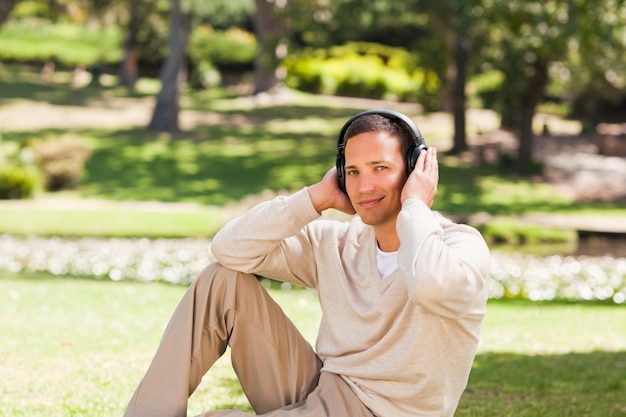 Mens die aan muziek in het park luistert