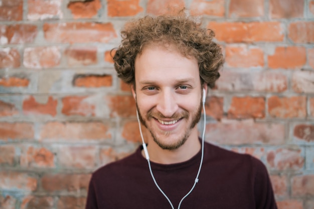 Mens die aan muziek met oortelefoons luistert.