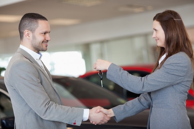 Mens die autosleutels ontvangt terwijl het schudden van hand