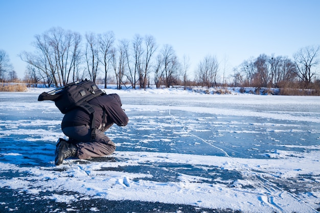 Mens die beeldenrivier neemt die in ijs en sneeuw wordt behandeld