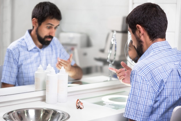 Mens die contactlens in oftalmologiekliniek zet.