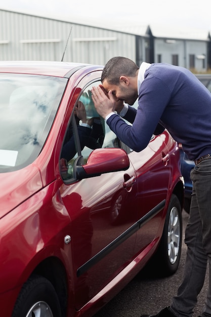 Mens die door het venster van de auto kijkt