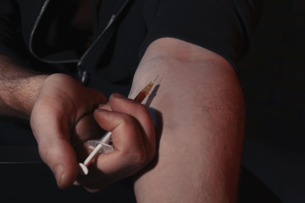 Mens die drugs op donkere close-up neemt als achtergrond