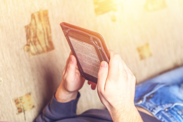 Mens die een eBook op digitaal tabletapparaat leest.