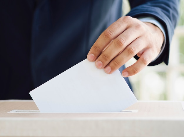 Foto mens die een lege stemming in verkiezingsdoos zet