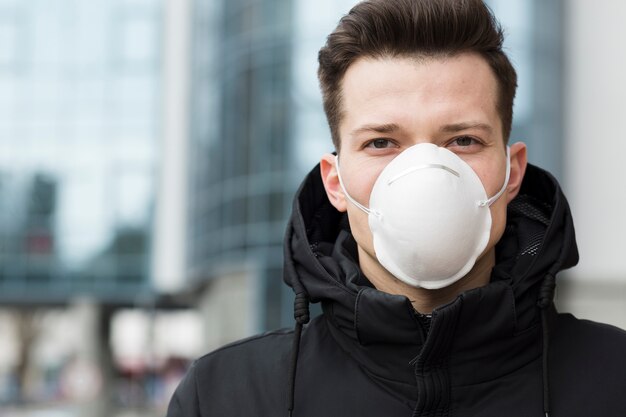 Mens die een medisch masker buiten draagt