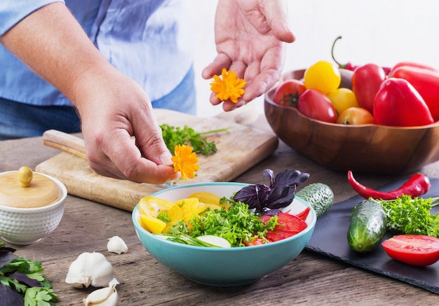 Mens die een vegetarische salade kookt