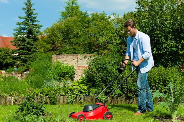 Mens die het gazon met machine maait