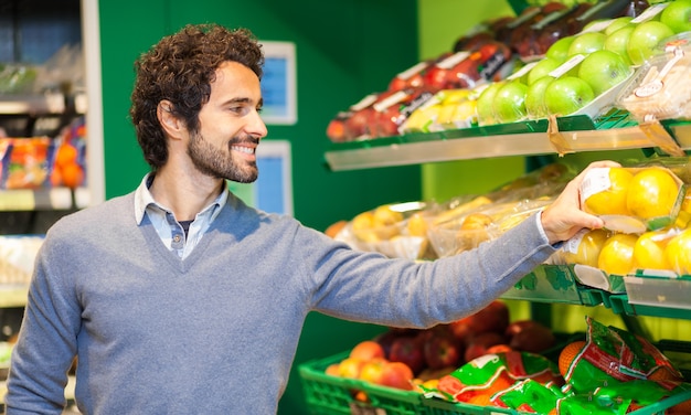 Mens die in een supermarkt winkelt