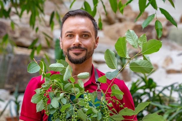 Mens die jonge boom houdt en voorbereidingen treft om in grond te planten.