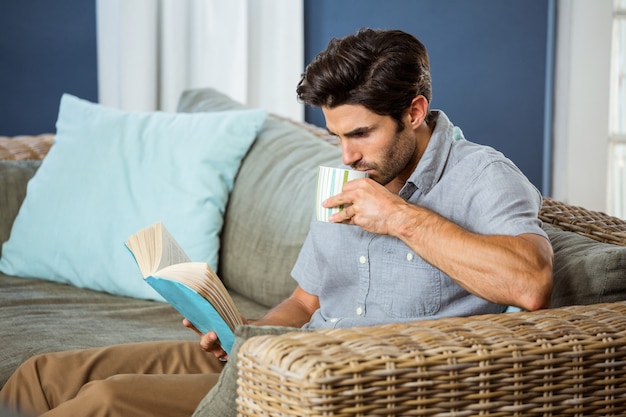 Mens die koffie heeft terwijl het lezen van boek