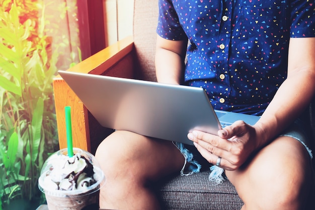 Mens die Laptop in koffie met behulp van. Proceswerk.