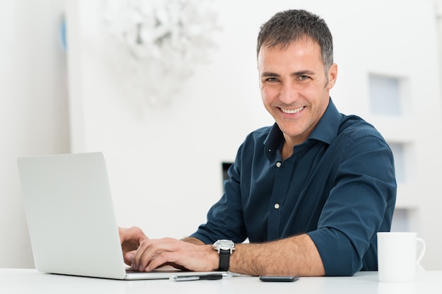 Mens Die Laptop Met Behulp Van Bij Bureau