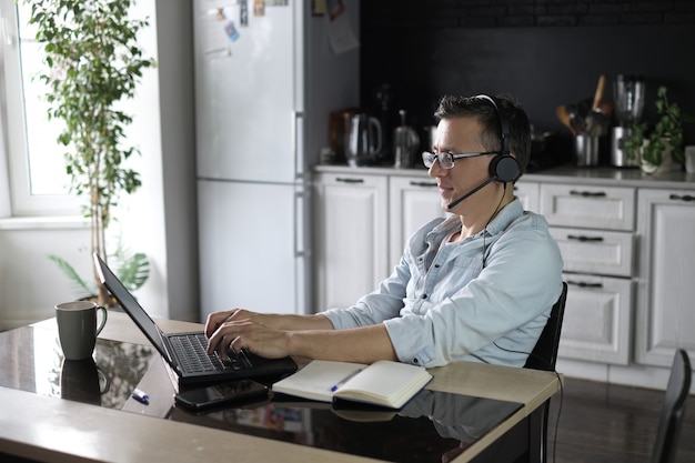 Mens die laptop voor het online thuis werken met behulp van